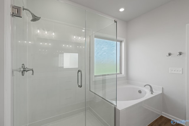 bathroom featuring hardwood / wood-style floors and separate shower and tub