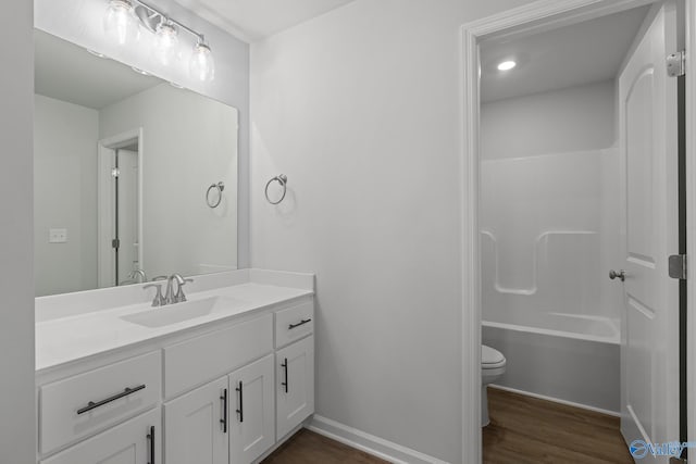 full bathroom with bathing tub / shower combination, toilet, vanity, and hardwood / wood-style flooring