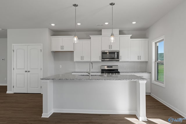 kitchen with sink, stainless steel appliances, an island with sink, and white cabinetry