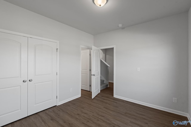 unfurnished bedroom featuring a closet and dark hardwood / wood-style floors