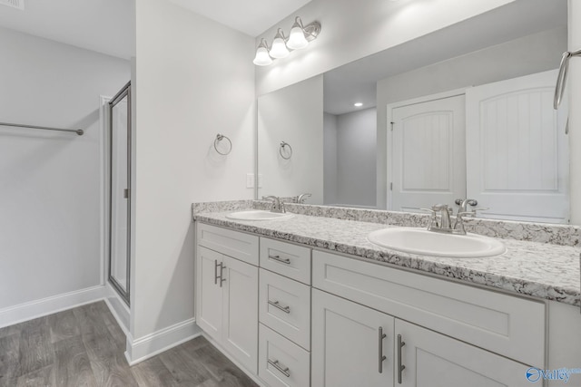 bathroom featuring a shower with door, vanity, and wood-type flooring