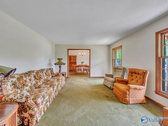 1913 Ruth St, Scottsboro, AL 35769 - living area featuring baseboards, carpet flooring, a textured ceiling, and a notable chandelier