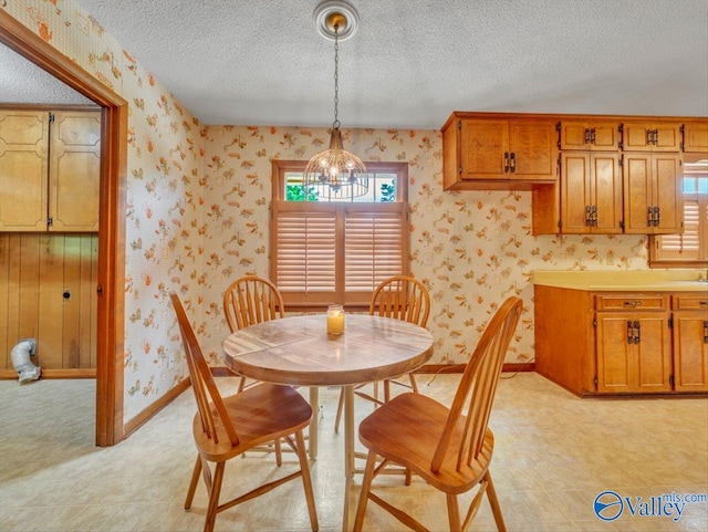 1913 Ruth St, Scottsboro, AL 35769 - dining area with baseboards, a textured ceiling, a notable chandelier, and wallpapered walls