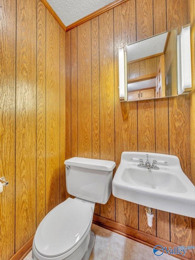 1913 Ruth St, Scottsboro, AL 35769 - half bathroom featuring a textured ceiling, a sink, baseboards, toilet, and wooden walls