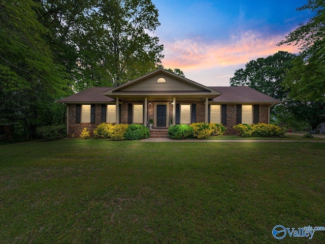 1913 Ruth St, Scottsboro, AL 35769 - view of front facade featuring a lawn, a porch, and brick siding