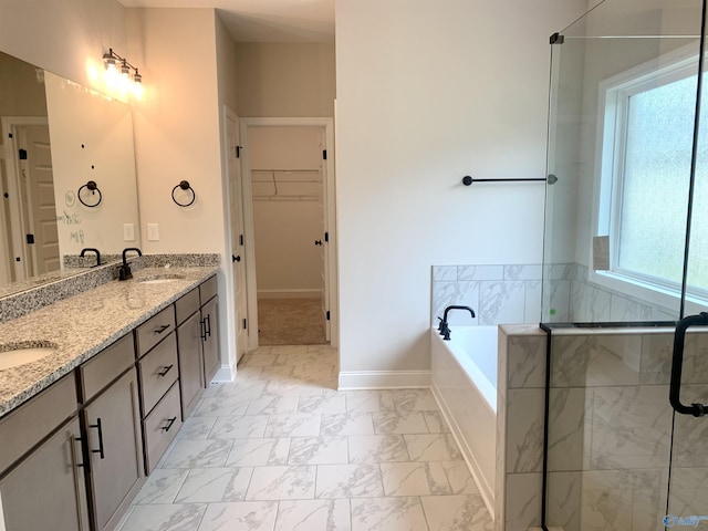 bathroom featuring a sink, double vanity, a garden tub, a spacious closet, and marble finish floor