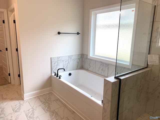 bathroom with a walk in shower, a garden tub, marble finish floor, and baseboards