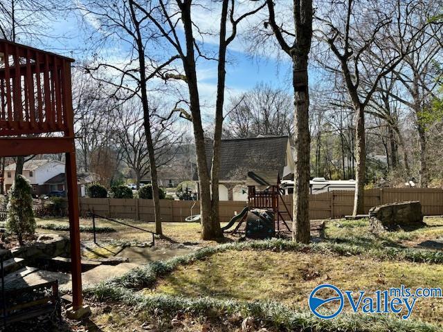 view of yard featuring fence and a playground