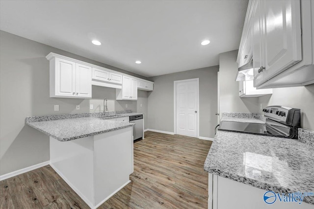 kitchen featuring white cabinetry, light stone counters, appliances with stainless steel finishes, kitchen peninsula, and hardwood / wood-style flooring