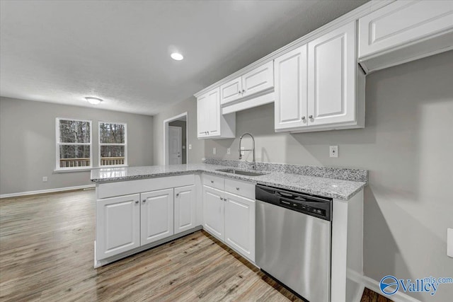 kitchen with sink, light hardwood / wood-style flooring, dishwasher, white cabinetry, and kitchen peninsula