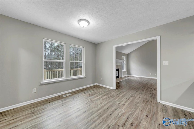 spare room featuring a textured ceiling and light wood-type flooring