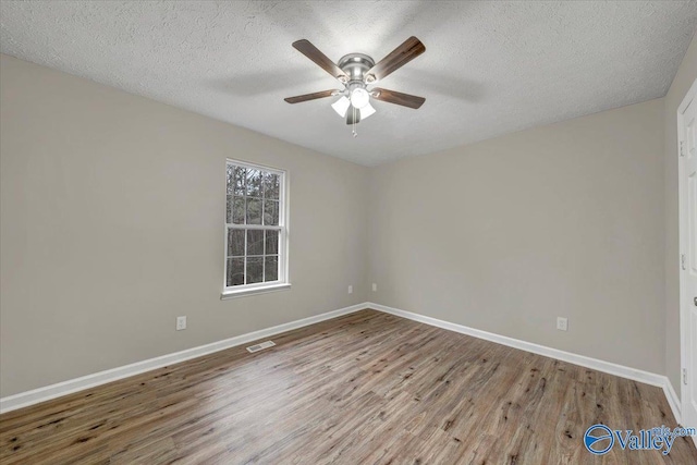 unfurnished room with ceiling fan, hardwood / wood-style flooring, and a textured ceiling