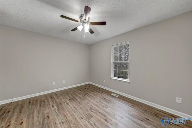 spare room with ceiling fan, light hardwood / wood-style floors, and a textured ceiling