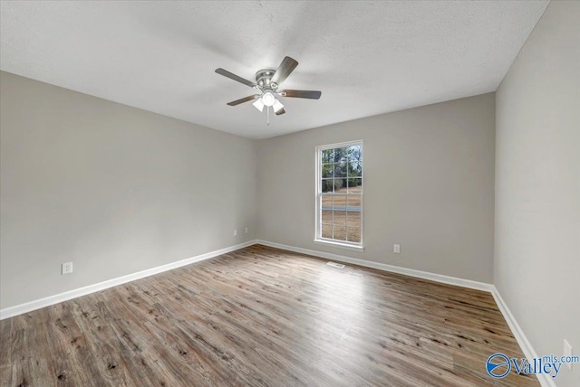 unfurnished room with hardwood / wood-style flooring, ceiling fan, and a textured ceiling