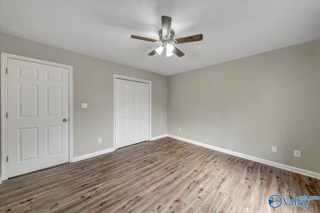 unfurnished bedroom featuring hardwood / wood-style flooring, a closet, and ceiling fan