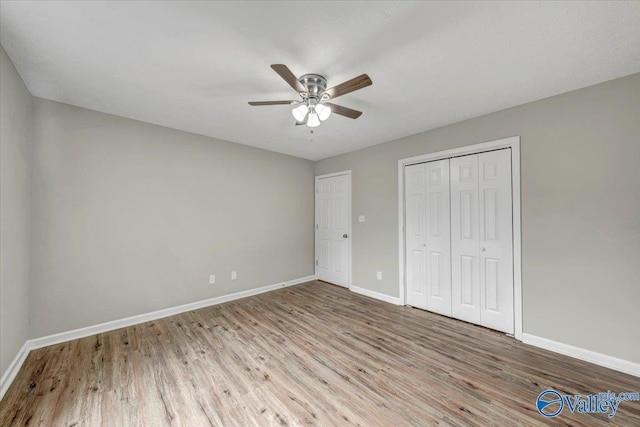 unfurnished bedroom featuring ceiling fan, light wood-type flooring, and a closet