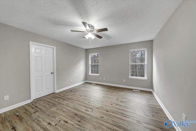 unfurnished room featuring hardwood / wood-style flooring, a textured ceiling, and ceiling fan