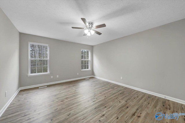 spare room featuring hardwood / wood-style flooring, ceiling fan, and a textured ceiling