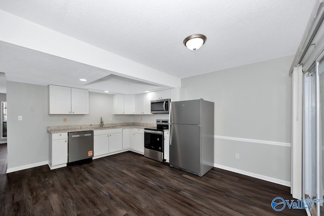 2007B Reaches Pl SW Unit B, Huntsville, AL 35802 - kitchen with stainless steel appliances, a sink, dark wood finished floors, baseboards, and a textured ceiling