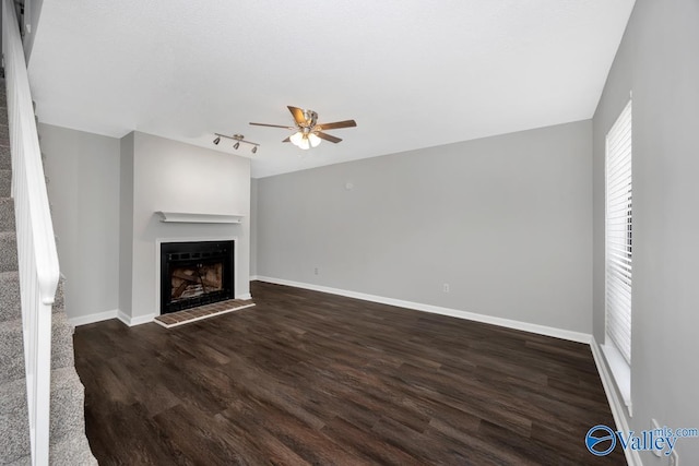 2007B Reaches Pl SW Unit B, Huntsville, AL 35802 - unfurnished living room featuring ceiling fan, a fireplace, dark wood-style flooring, baseboards, and track lighting