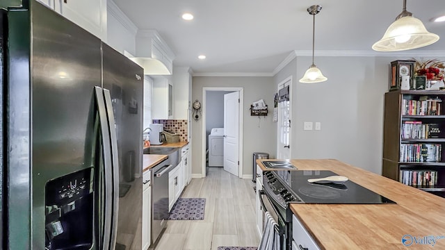 kitchen featuring appliances with stainless steel finishes, washer / dryer, butcher block countertops, and white cabinets