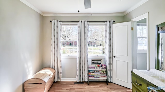 living area with light wood-style flooring, ornamental molding, and baseboards