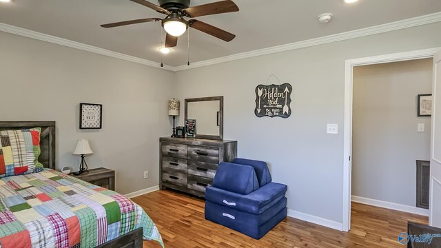 bedroom with wood finished floors, a ceiling fan, baseboards, visible vents, and crown molding