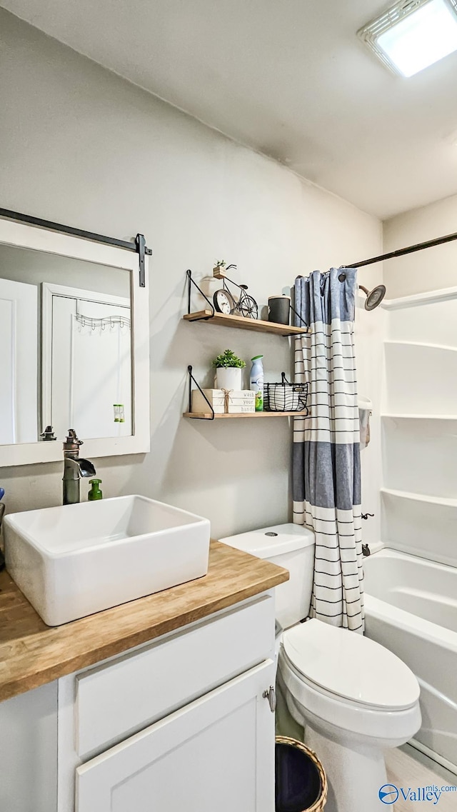 bathroom with toilet, shower / bath combo with shower curtain, and vanity