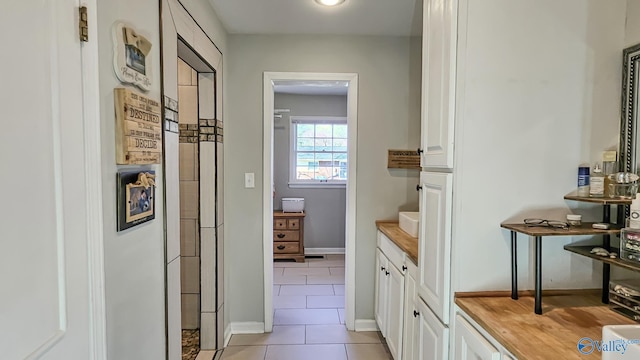 bathroom with baseboards and tile patterned floors