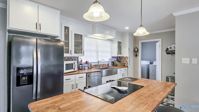 kitchen featuring cooktop, white microwave, butcher block counters, refrigerator with ice dispenser, and stainless steel dishwasher