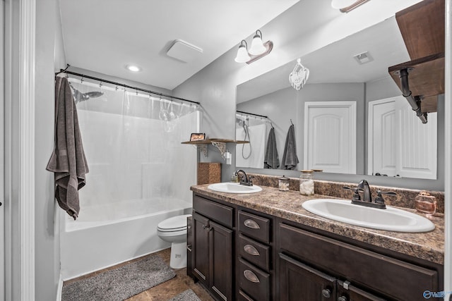 bathroom featuring visible vents, toilet, double vanity, and a sink