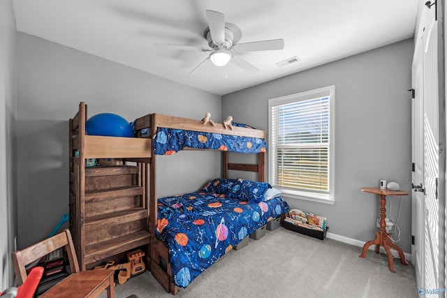 carpeted bedroom with visible vents, ceiling fan, and baseboards