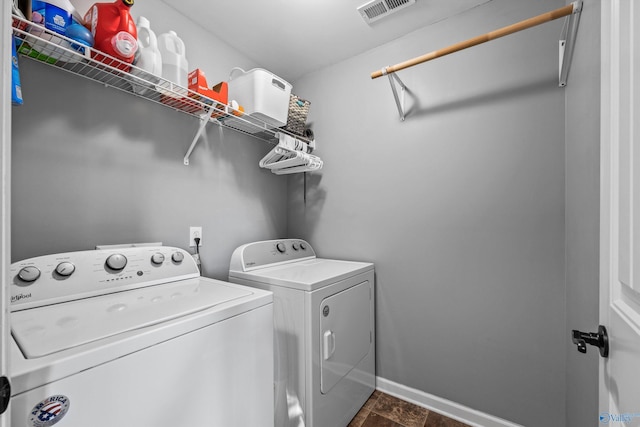 clothes washing area with independent washer and dryer, visible vents, laundry area, and baseboards
