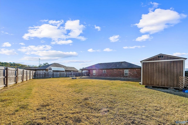 view of yard with an outbuilding, a shed, and a fenced backyard