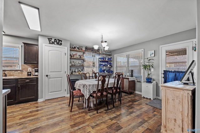 dining space with wood finished floors, a notable chandelier, and plenty of natural light