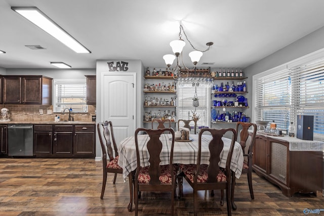dining space featuring dark wood-type flooring, a chandelier, and visible vents