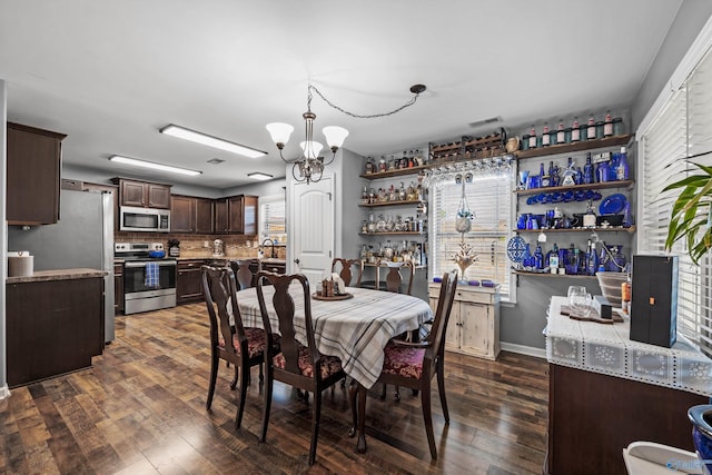 dining room with dark wood finished floors, visible vents, and a notable chandelier