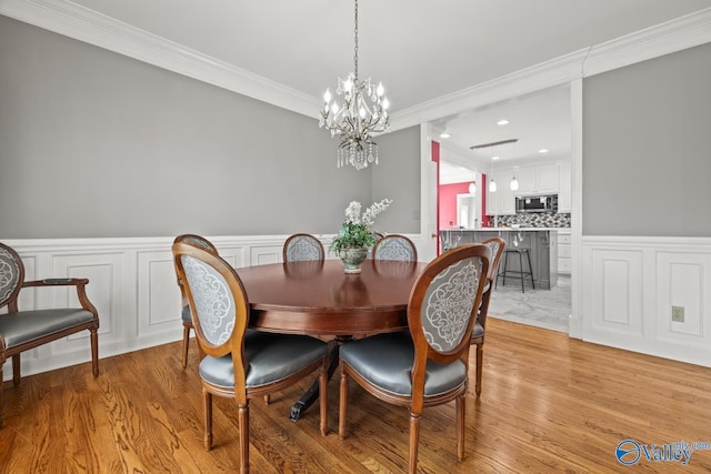 130 Kingswood Dr, Huntsville, AL 35806 - dining room featuring a chandelier, light wood finished floors, ornamental molding, and a wainscoted wall