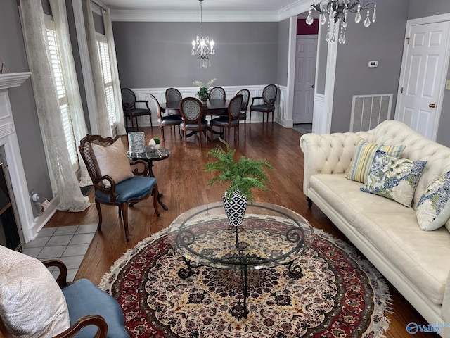 130 Kingswood Dr, Huntsville, AL 35806 - living area with ornamental molding, visible vents, a wainscoted wall, wood finished floors, and a notable chandelier