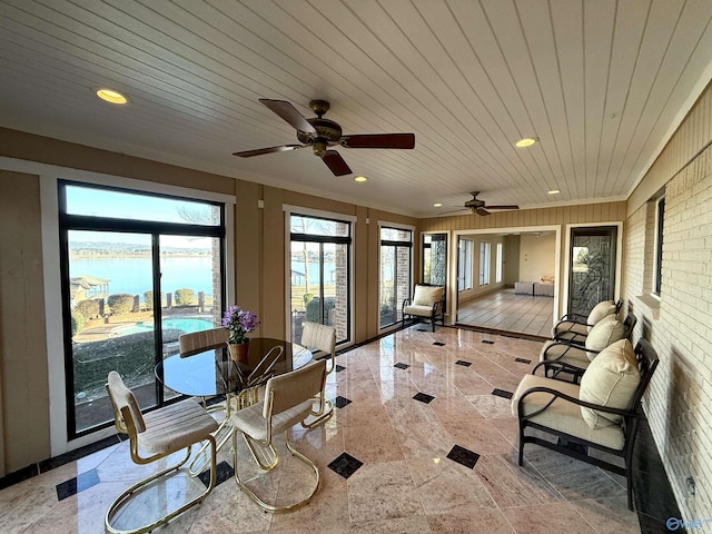 sunroom with a water view, ceiling fan, and wooden ceiling