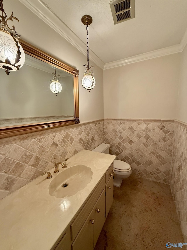 bathroom featuring toilet, vanity, tile walls, and ornamental molding