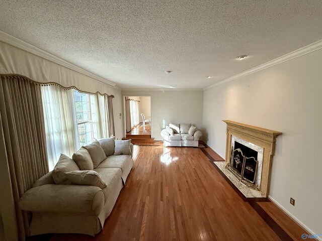 living room with wood-type flooring, crown molding, and a textured ceiling