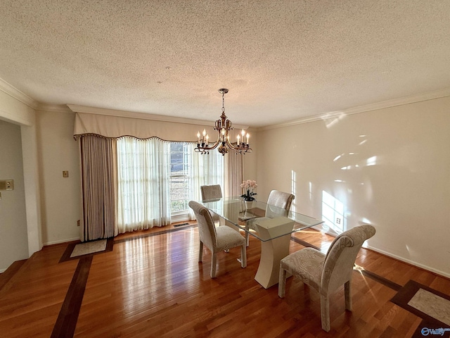 dining area featuring wood-type flooring, a notable chandelier, and a textured ceiling