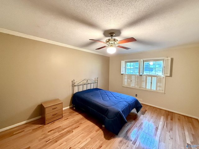 bedroom with light wood-type flooring, ceiling fan, ornamental molding, and a textured ceiling