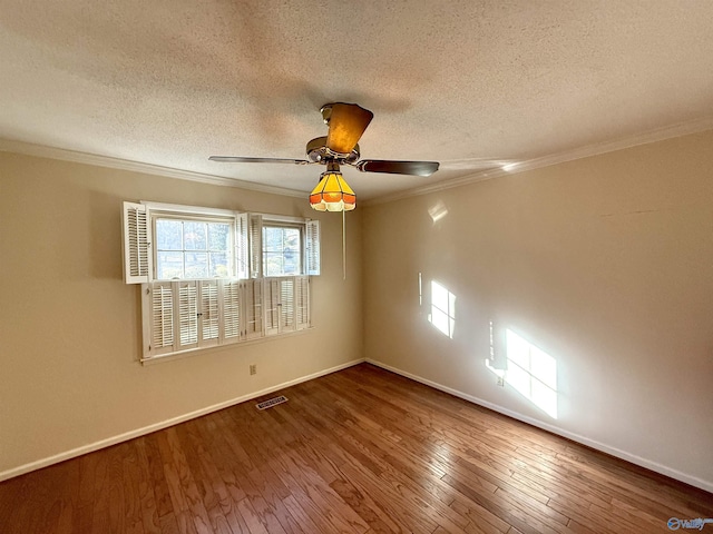 spare room featuring ceiling fan, wood-type flooring, crown molding, and a textured ceiling