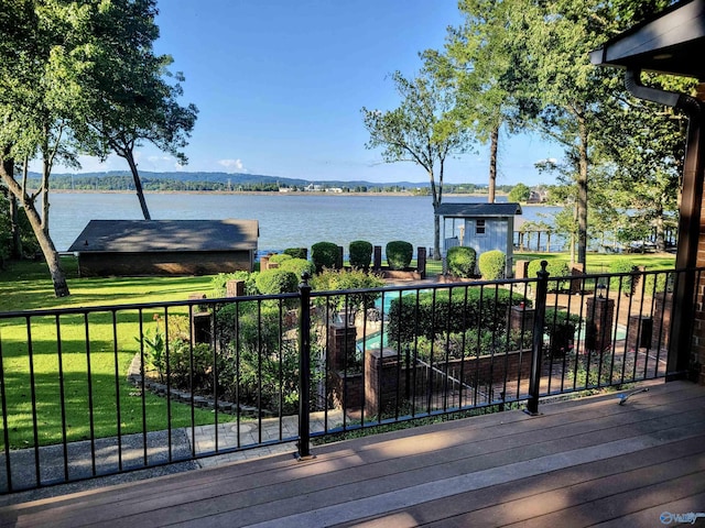 wooden deck featuring a lawn and a water view