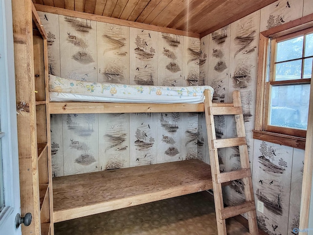 unfurnished bedroom with wooden ceiling and wooden walls