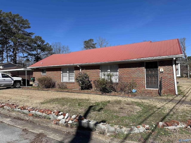 ranch-style house featuring metal roof and brick siding