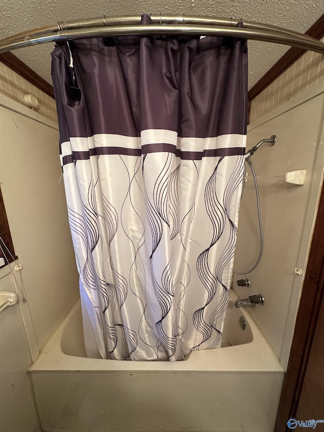 full bath featuring shower / bath combination with curtain and a textured ceiling