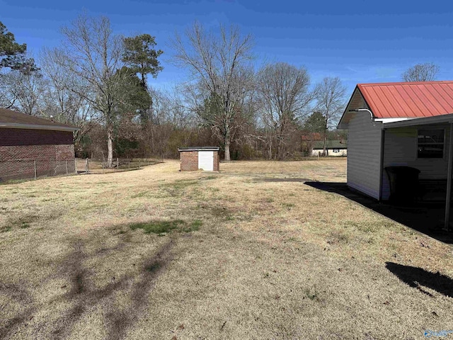 view of yard featuring a storage shed, fence, and an outdoor structure